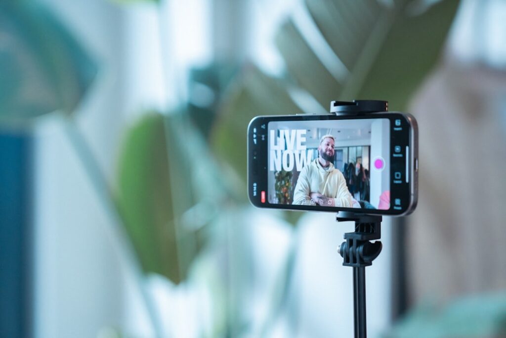 Smartphone on tripod recording live video stream indoors.